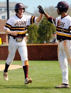 Sophomore outfielder Steven Whitaker (No. 7) celebrates his scoring by giving teammate Jeremy Glore a high five after arriving  home. (photo by Bill Roa)